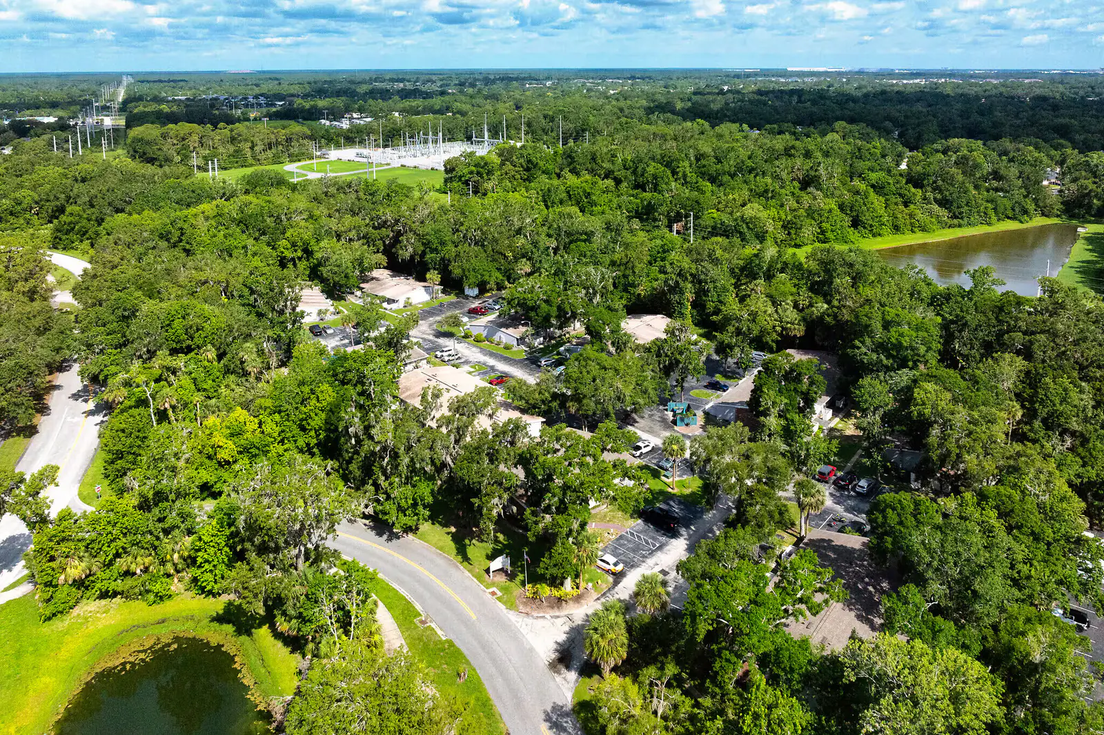Aerial view of Bungalows of Port Orange with single-story homes, trees, and ponds.