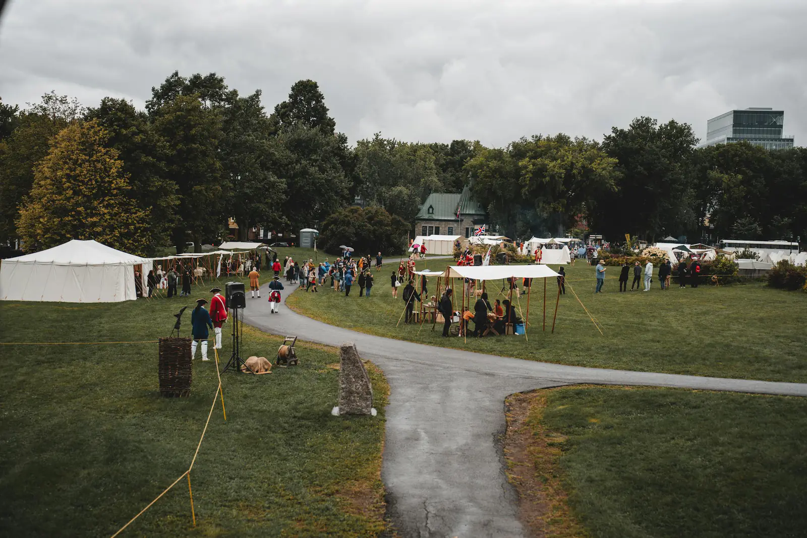 An outdoor community event with tents and green space.