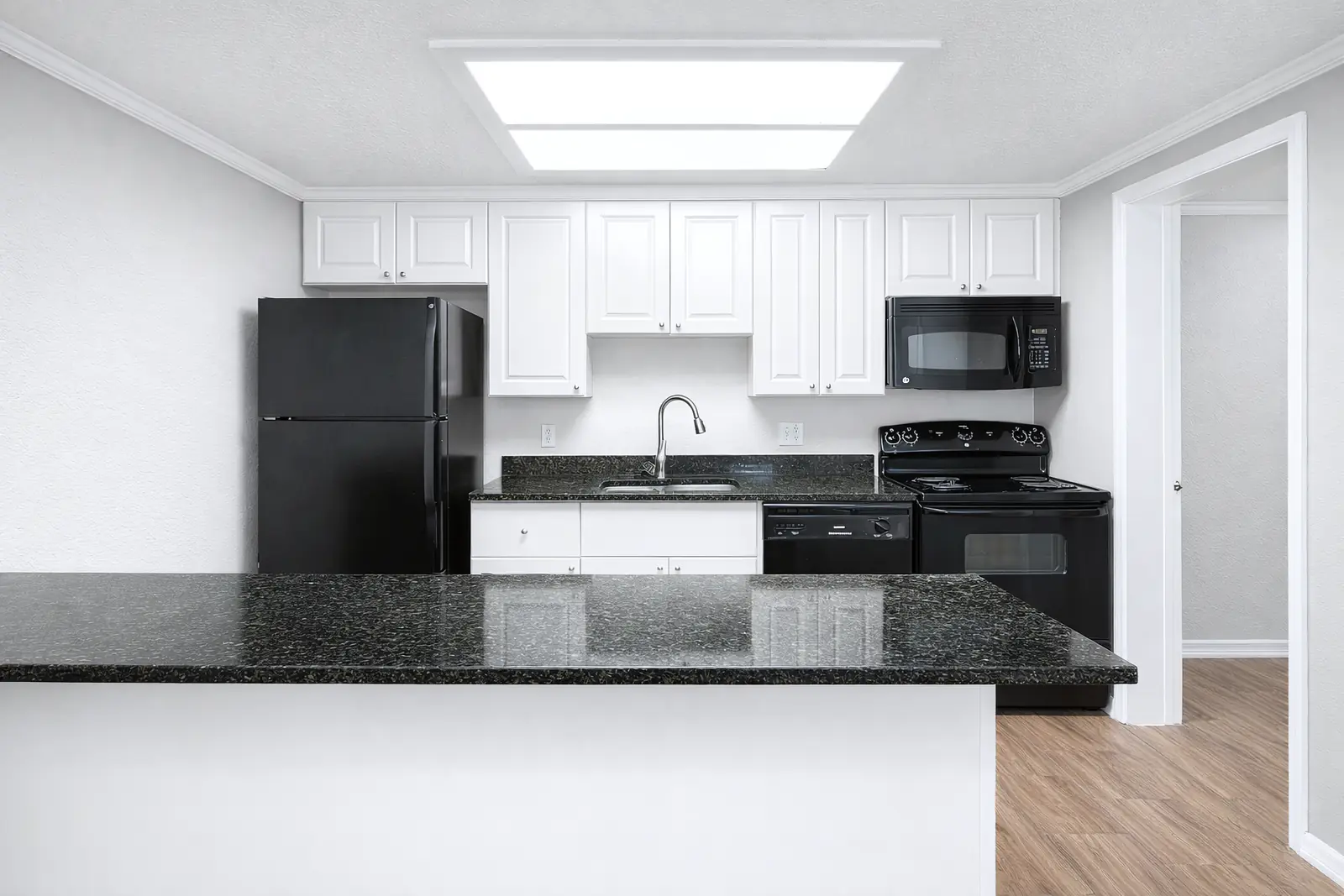 Bright kitchen with white cabinets and a long counter.