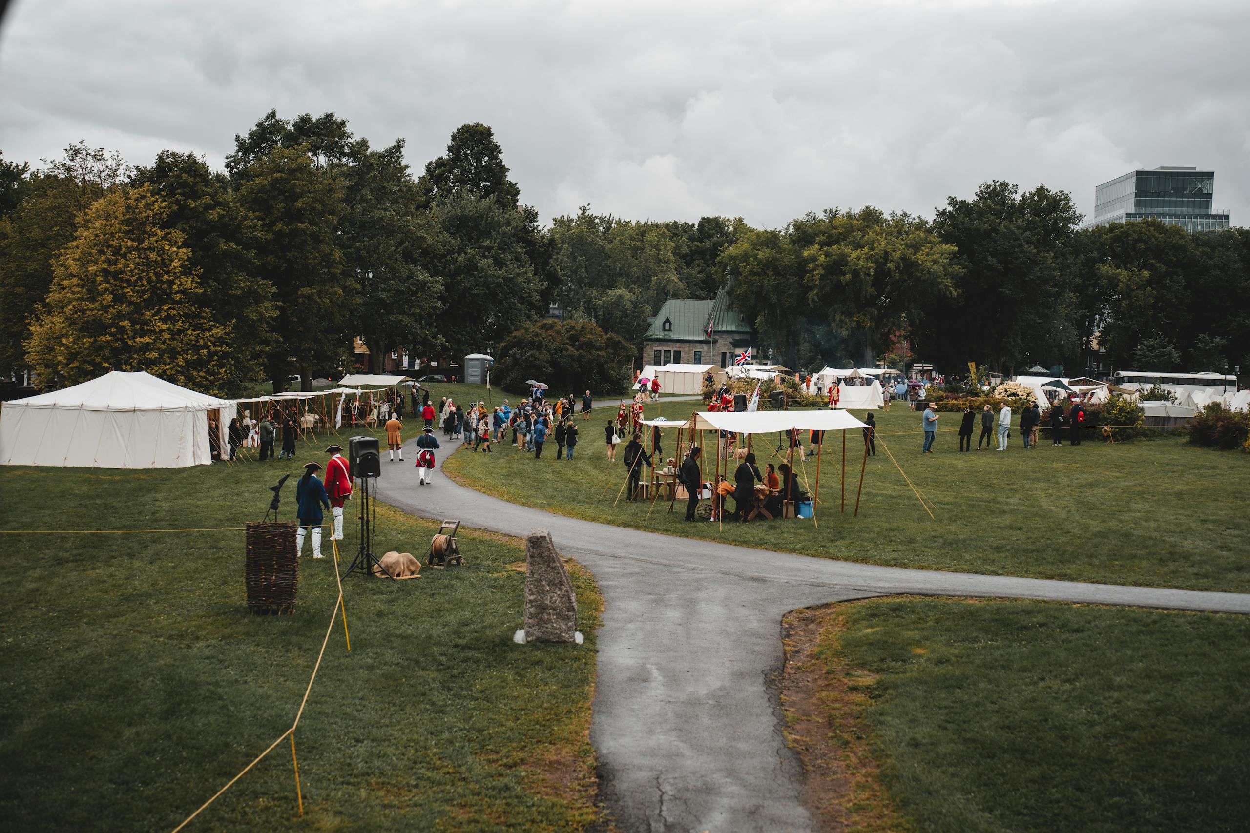 A lively outdoor festival scene with tents and greenery, featuring people in colorful attire.